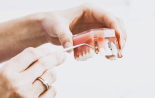 woman looking at dental implant up close