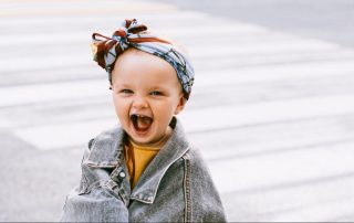 Kid laughing in an oversized jacket