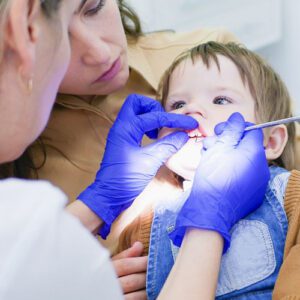 toddler getting teeth checked by dentist