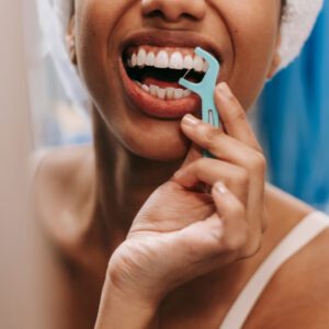 woman flossing teeth with pick and floss