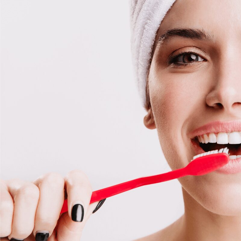 cheerful woman brushing her teeth