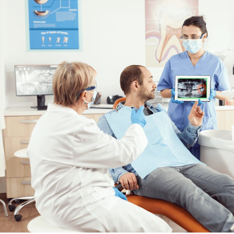 dental assistant showing xray of wisdom tooth